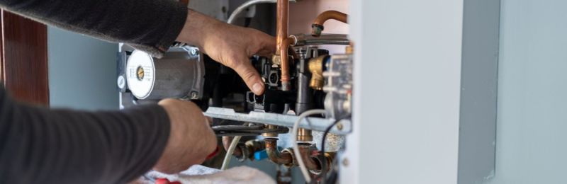 Furnace technician repairing a heating system in a San Diego home